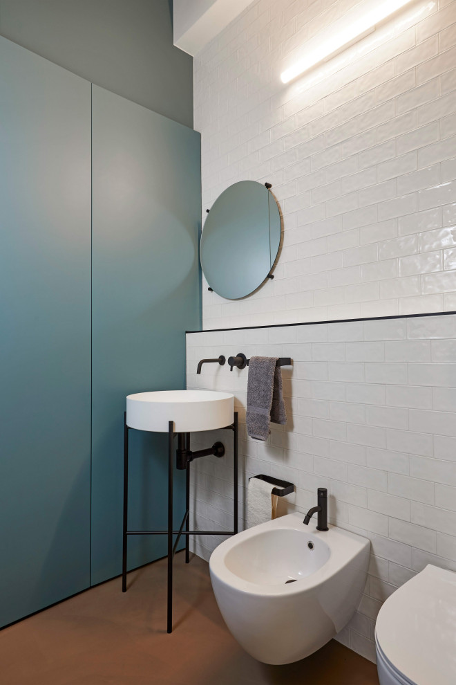 Inredning av ett modernt toalett, med en bidé, vit kakel, tunnelbanekakel, grå väggar, ett konsol handfat och brunt golv