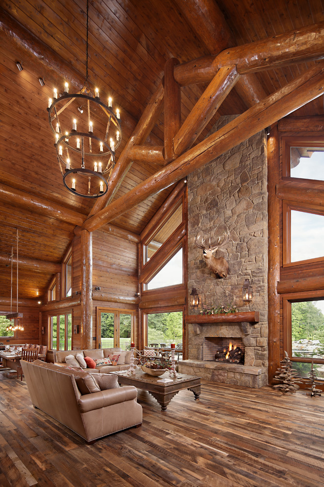 Inspiration for a large rustic open concept medium tone wood floor family room remodel in Boise with a standard fireplace, a stone fireplace and no tv