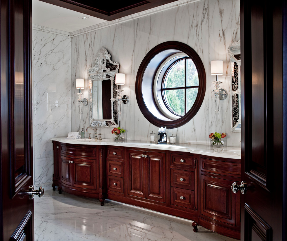Large traditional bathroom in Detroit with an undermount sink, raised-panel cabinets, dark wood cabinets, marble benchtops, white tile, stone slab, a claw-foot tub, a two-piece toilet, white walls and marble floors.