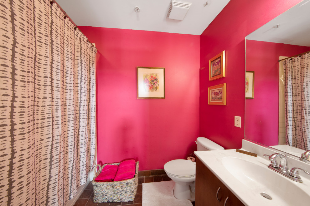 Design ideas for a small transitional master bathroom in Tampa with flat-panel cabinets, brown cabinets, a drop-in tub, a shower/bathtub combo, a one-piece toilet, pink walls, cement tiles, an integrated sink, laminate benchtops, brown floor, a shower curtain, white benchtops, a laundry, a double vanity and a floating vanity.