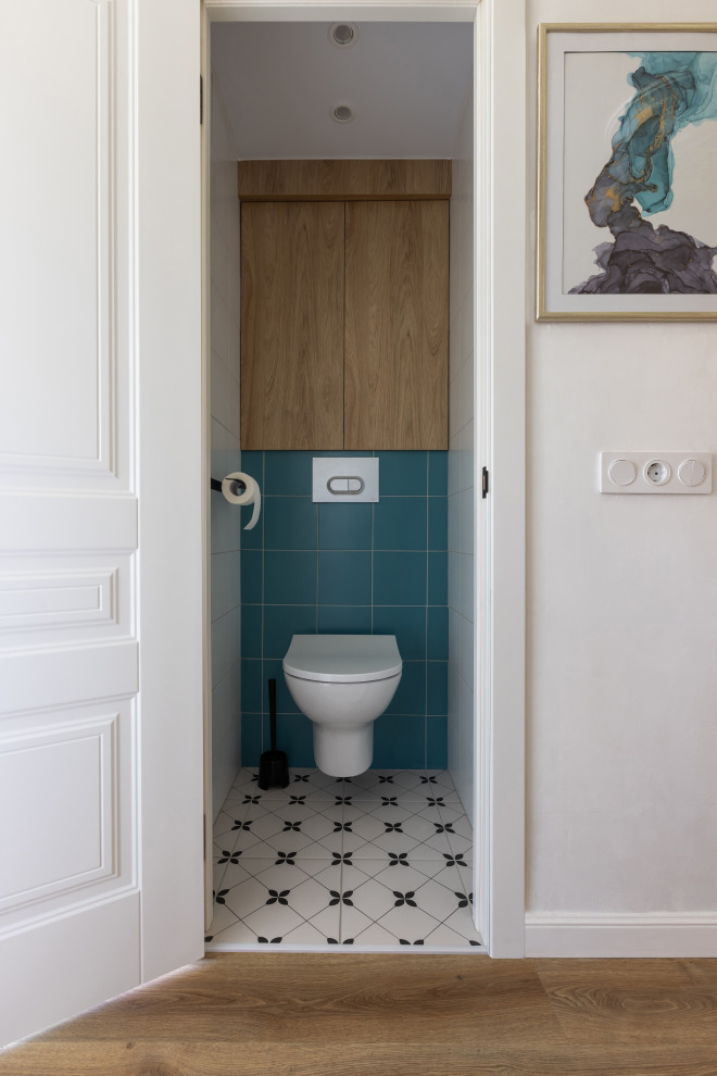 Inspiration pour un petit WC et toilettes design en bois clair avec un placard à porte plane, un carrelage blanc, des carreaux de céramique, un mur blanc, un sol en carrelage de porcelaine et un sol blanc.