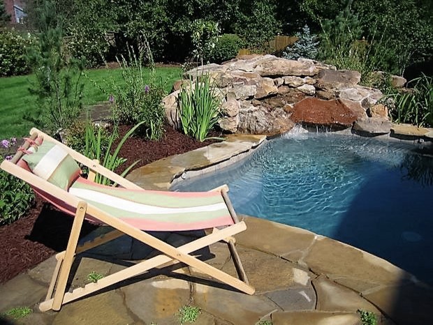 Example of a mid-sized minimalist backyard stone and custom-shaped natural pool fountain design in Kansas City