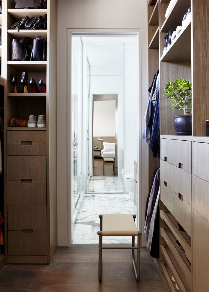 Mid-sized modern gender-neutral walk-in wardrobe in New York with flat-panel cabinets, light wood cabinets, medium hardwood floors and brown floor.