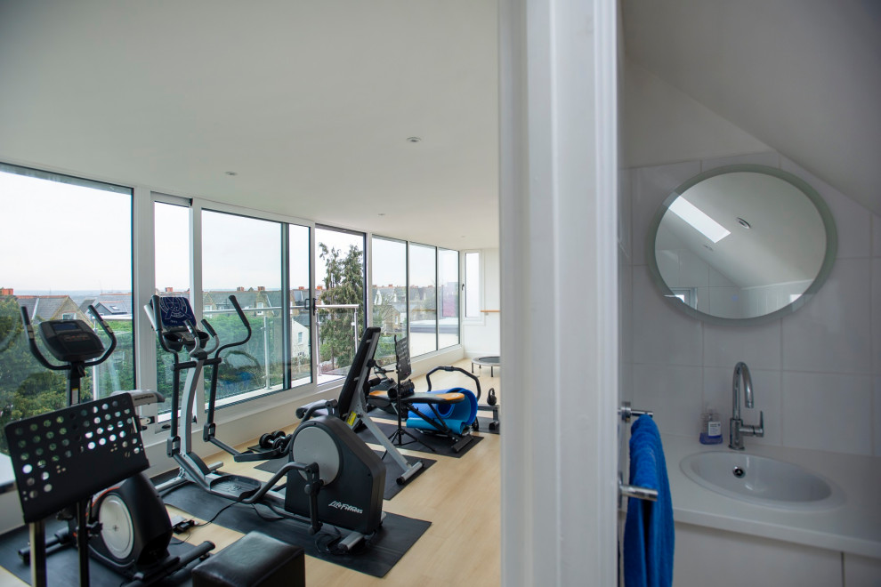 Multifunktionaler, Großer Moderner Fitnessraum mit weißer Wandfarbe, Laminat und gelbem Boden in London