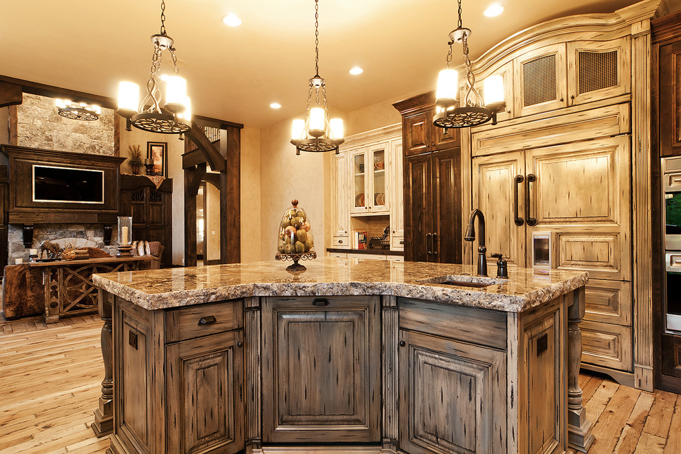 This is an example of a large country galley eat-in kitchen in Salt Lake City with a farmhouse sink, raised-panel cabinets, dark wood cabinets, granite benchtops, beige splashback, porcelain splashback, stainless steel appliances, light hardwood floors and with island.