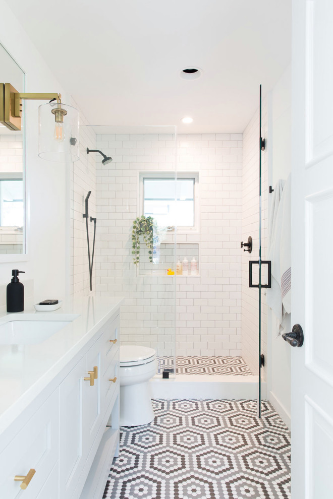Inspiration for a mid-sized transitional kids bathroom in San Francisco with shaker cabinets, white cabinets, an alcove shower, white tile, subway tile, white walls, mosaic tile floors, an undermount sink, multi-coloured floor, a hinged shower door, white benchtops, a single vanity and a freestanding vanity.