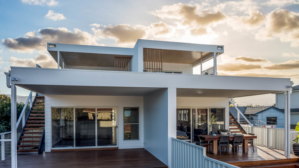 Modern two-storey white duplex exterior with mixed siding, a flat roof and a metal roof.
