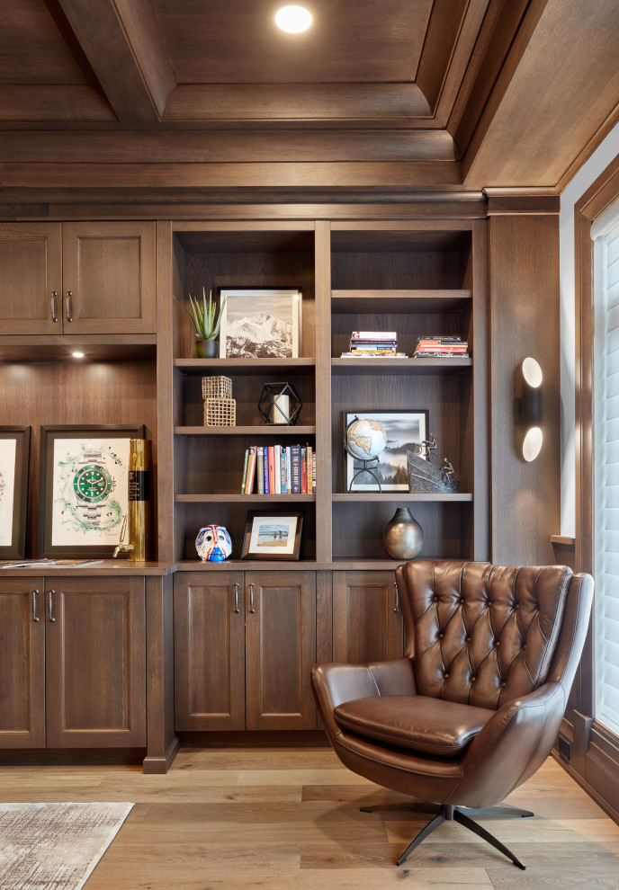 Inspiration för klassiska hemmabibliotek, med ljust trägolv, ett fristående skrivbord och brunt golv