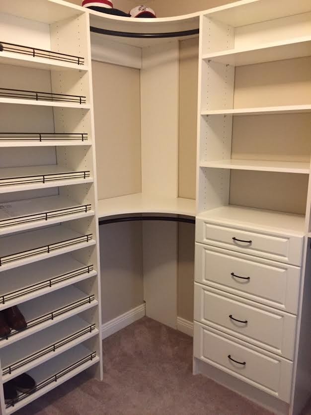 This is an example of a large modern gender-neutral walk-in wardrobe in Huntington with raised-panel cabinets, white cabinets, carpet and brown floor.