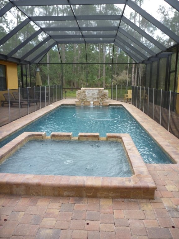 Mid-sized mediterranean indoor round natural pool in Tampa with brick pavers.