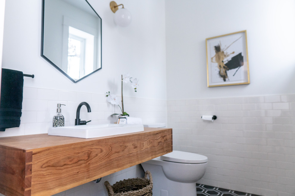 Inspiration for a mid-sized transitional 3/4 porcelain tile ceramic tile and black floor bathroom remodel with open cabinets, medium tone wood cabinets, a one-piece toilet, white walls, a vessel sink, wood countertops and brown countertops