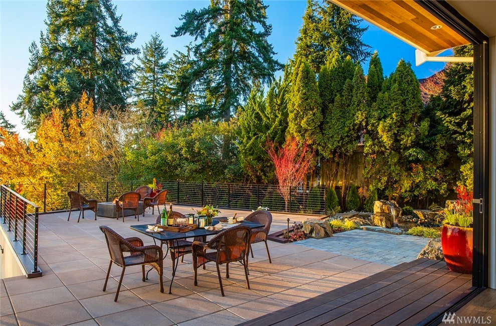 Photo of a large contemporary backyard patio in Seattle with a fire feature, concrete slab and no cover.