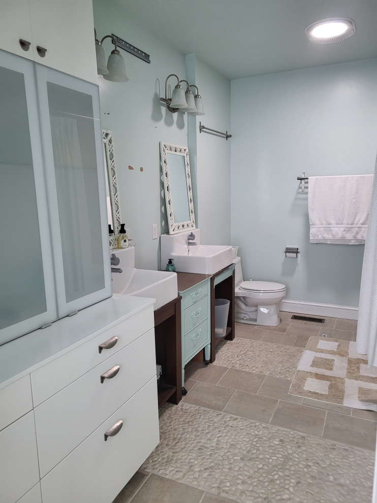 Foto på ett litet eklektiskt grön badrum för barn, med luckor med infälld panel, gröna skåp, ett badkar i en alkov, en dusch/badkar-kombination, en toalettstol med hel cisternkåpa, flerfärgad kakel, mosaik, blå väggar, klinkergolv i porslin, ett avlångt handfat, träbänkskiva, beiget golv och dusch med duschdraperi