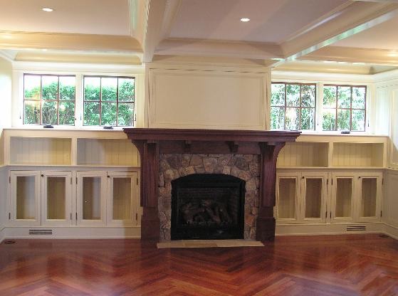 Photo of a mid-sized traditional enclosed family room in Portland Maine with medium hardwood floors, white walls, a ribbon fireplace and a stone fireplace surround.