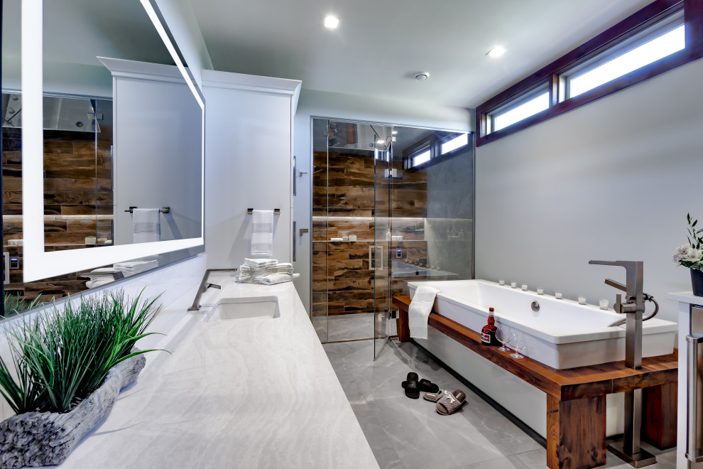 Exempel på ett mellanstort klassiskt vit vitt en-suite badrum, med luckor med infälld panel, grå skåp, ett fristående badkar, en kantlös dusch, en bidé, brun kakel, grå väggar, klinkergolv i porslin, ett undermonterad handfat, bänkskiva i kvarts, grått golv och dusch med gångjärnsdörr