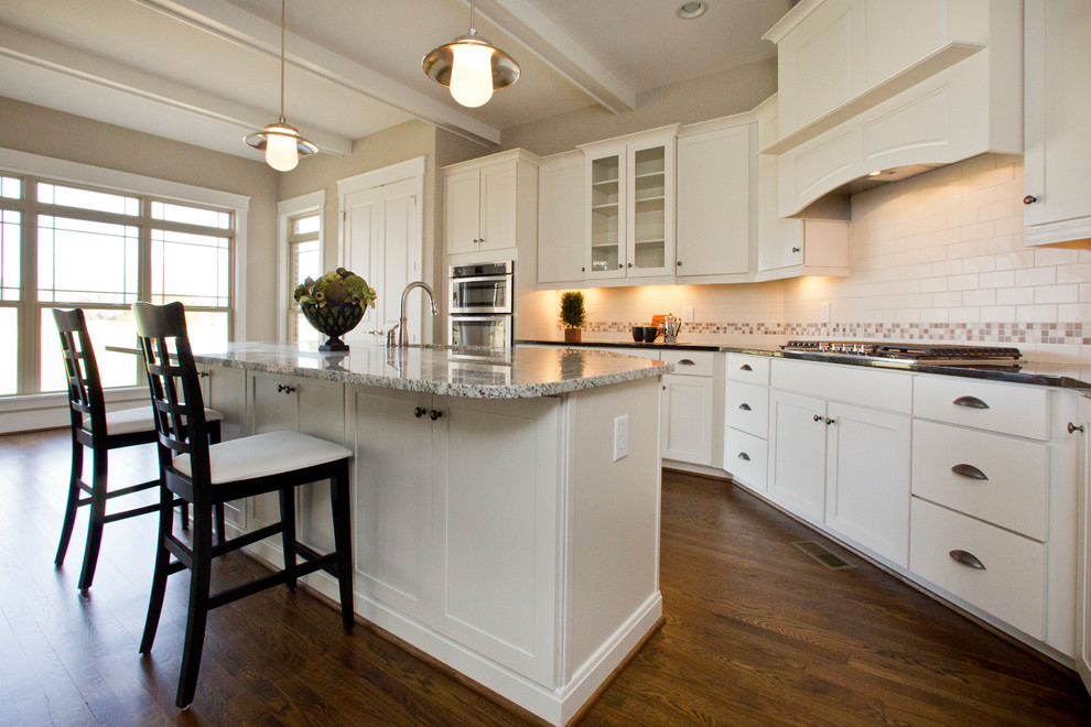Inspiration for an arts and crafts l-shaped eat-in kitchen in Raleigh with white cabinets, stainless steel appliances, with island and brown floor.