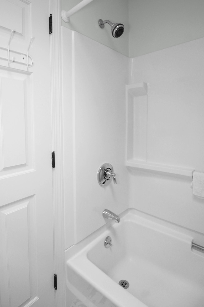 Photo of a small transitional master bathroom in Boston with shaker cabinets, white cabinets, an alcove tub, a shower/bathtub combo, a two-piece toilet, white tile, ceramic tile, green walls, ceramic floors, an undermount sink, engineered quartz benchtops, multi-coloured floor, a shower curtain and grey benchtops.