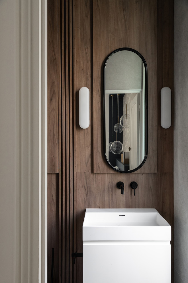 Mid-sized contemporary 3/4 wet room bathroom in Paris with white cabinets, a wall-mount toilet, blue tile, brown walls, light hardwood floors, a vessel sink, a hinged shower door, white benchtops, a single vanity, a floating vanity and wood walls.