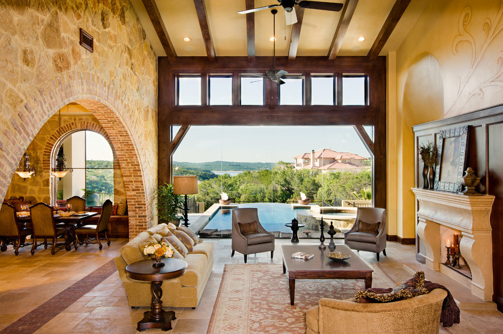 Inspiration for a large mediterranean formal open concept living room in Austin with beige walls, a standard fireplace, ceramic floors, a stone fireplace surround, no tv and beige floor.