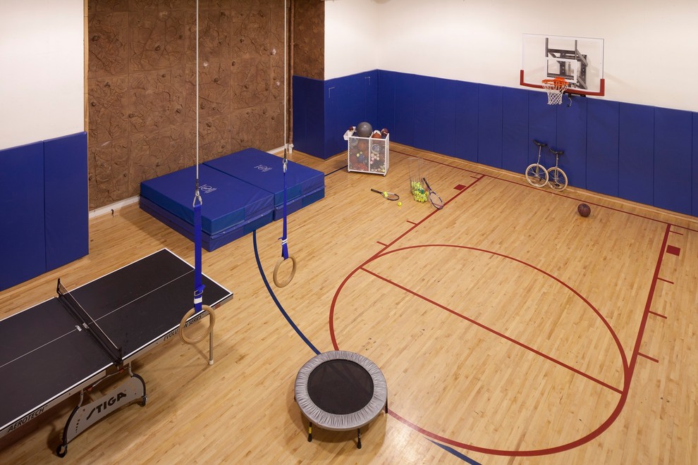 This is an example of an expansive traditional indoor sport court in Minneapolis with light hardwood floors and white walls.