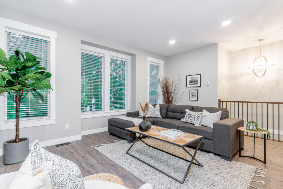 Mittelgroßes, Offenes Landhausstil Wohnzimmer mit grauer Wandfarbe, hellem Holzboden, Kamin und verputzter Kaminumrandung in Vancouver