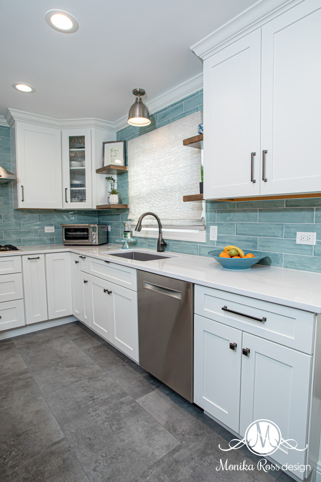 Foto på ett stort maritimt vit kök, med en undermonterad diskho, skåp i shakerstil, vita skåp, bänkskiva i kvarts, blått stänkskydd, stänkskydd i keramik, rostfria vitvaror, vinylgolv, en köksö och grått golv