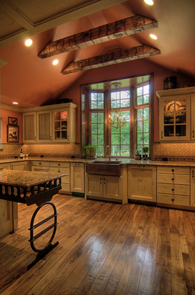 Inspiration for a mid-sized rustic l-shaped medium tone wood floor enclosed kitchen remodel with a farmhouse sink, distressed cabinets, granite countertops, beige backsplash, paneled appliances, a peninsula, recessed-panel cabinets and stone tile backsplash