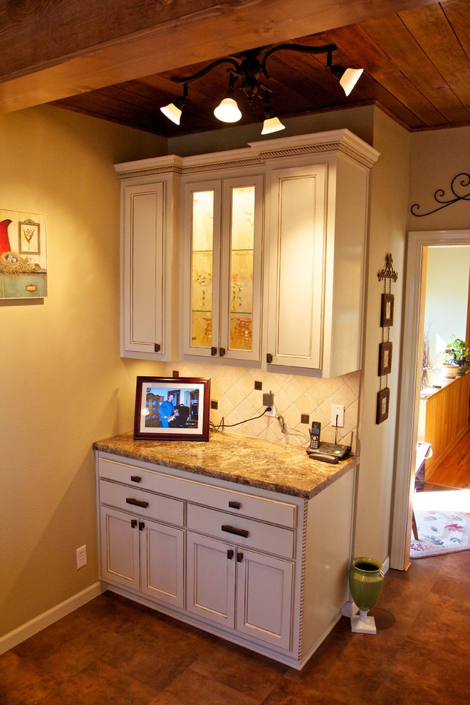 Inspiration for a small l-shaped kitchen remodel with a drop-in sink, raised-panel cabinets, white cabinets, laminate countertops, white backsplash, stone tile backsplash and black appliances