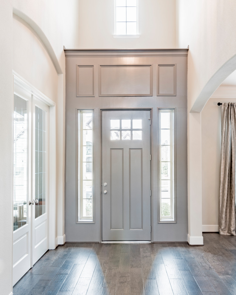 Источник вдохновения для домашнего уюта: большая входная дверь в стиле неоклассика (современная классика) с бежевыми стенами, темным паркетным полом, одностворчатой входной дверью, серой входной дверью и коричневым полом