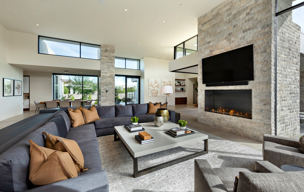 Inspiration for an expansive modern open concept living room in Phoenix with beige walls, porcelain floors, a standard fireplace, a metal fireplace surround, a wall-mounted tv and beige floor.