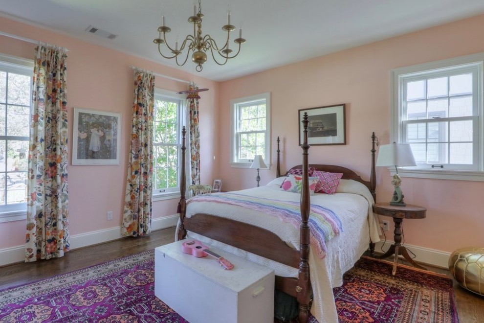 This is an example of a mid-sized traditional bedroom in Nashville with pink walls, medium hardwood floors and brown floor.