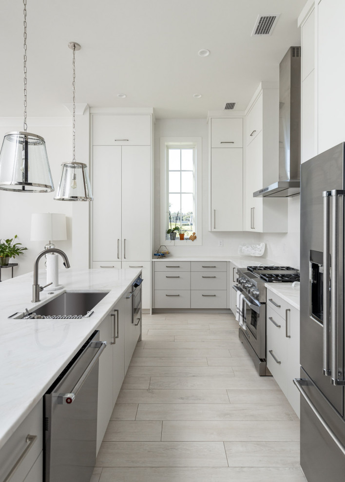 Inspiration for a mid-sized contemporary l-shaped open plan kitchen in New Orleans with an undermount sink, flat-panel cabinets, white cabinets, quartz benchtops, white splashback, porcelain splashback, stainless steel appliances, porcelain floors, with island, grey floor and white benchtop.