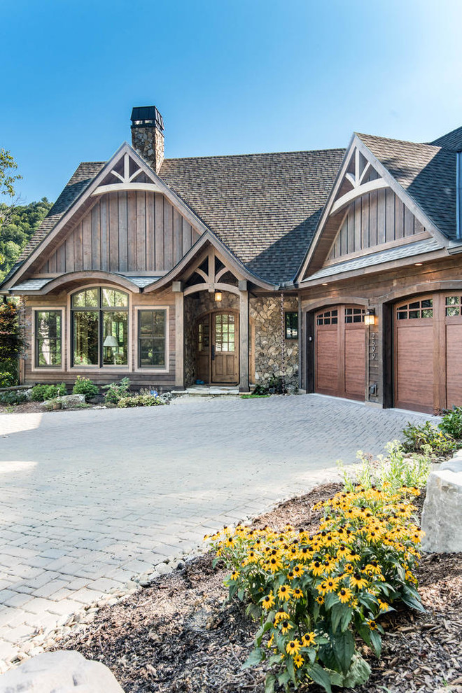 Mid-sized country two-storey brown house exterior in Other with mixed siding, a gable roof and a shingle roof.