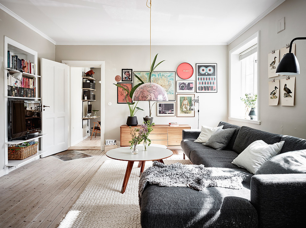 Design ideas for a scandinavian enclosed living room in Gothenburg with beige walls, light hardwood floors, no fireplace, a freestanding tv and beige floor.