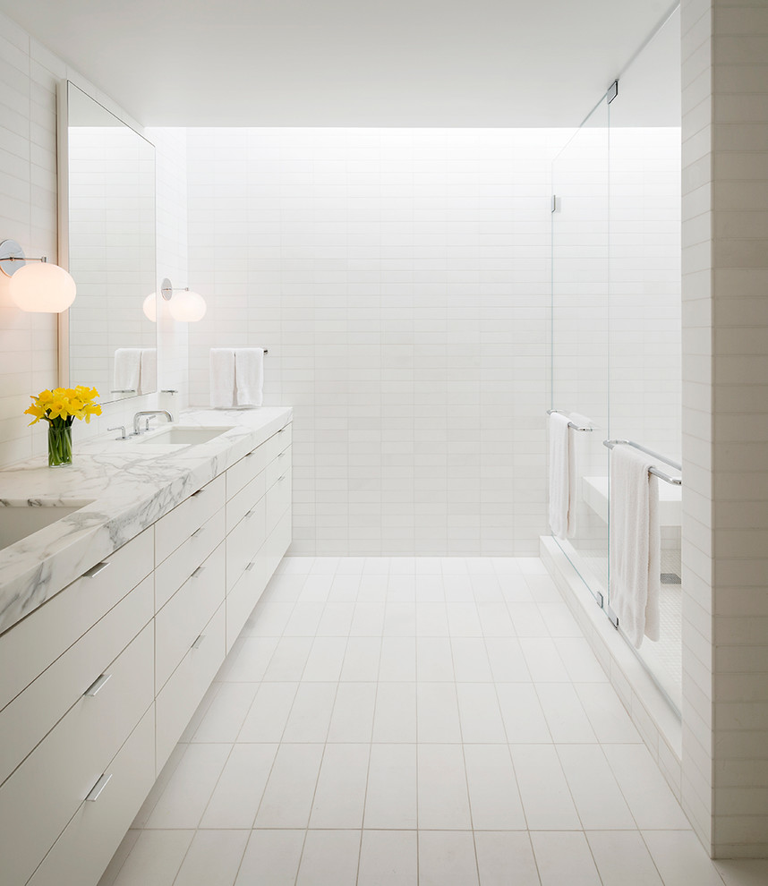 This is an example of a contemporary bathroom in San Francisco with marble benchtops and white tile.
