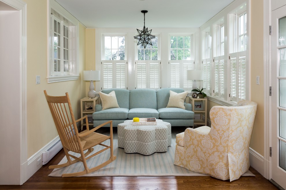 This is an example of a small traditional open concept living room in Boston with medium hardwood floors, brown floor and yellow walls.