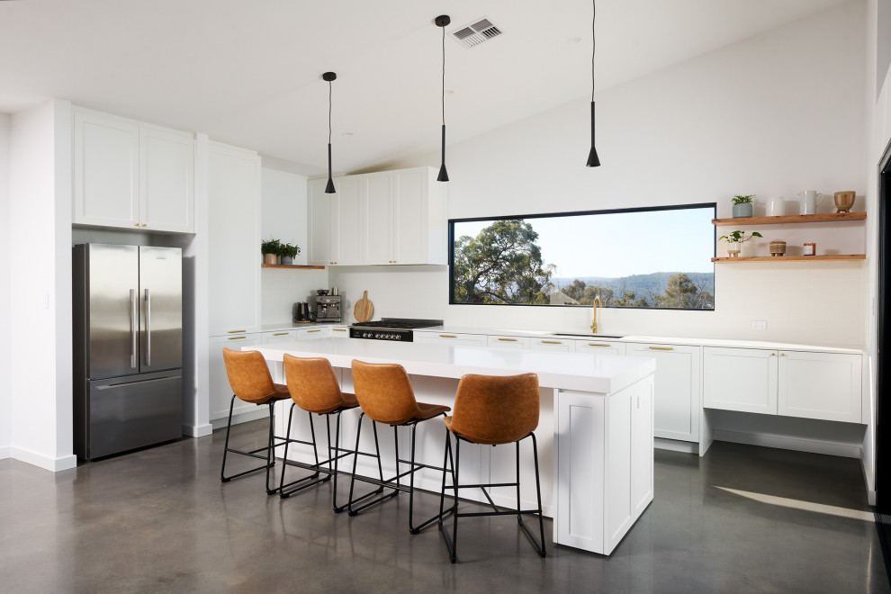 Design ideas for a mid-sized traditional l-shaped eat-in kitchen in Perth with a double-bowl sink, shaker cabinets, white cabinets, quartz benchtops, white splashback, subway tile splashback, black appliances, concrete floors, with island, grey floor, white benchtop and vaulted.