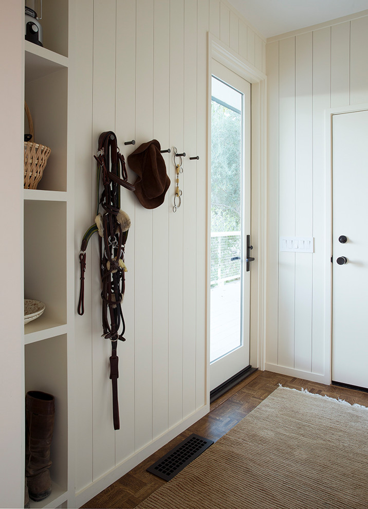 Photo of a country entryway in San Francisco with white walls, dark hardwood floors, a single front door, a glass front door and brown floor.
