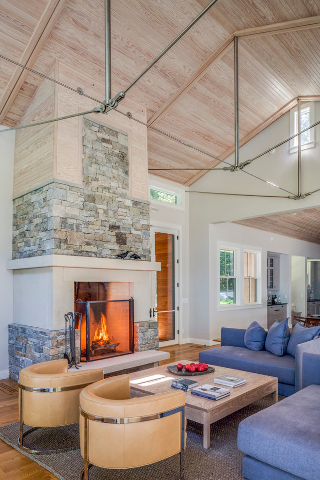 Inspiration for a large transitional open concept living room in Portland Maine with white walls, a two-sided fireplace, a stone fireplace surround and medium hardwood floors.