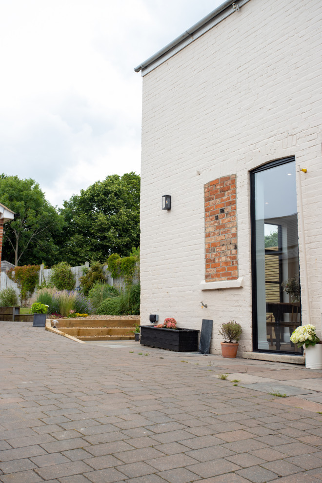 Foto di un patio o portico chic di medie dimensioni e dietro casa con pavimentazioni in mattoni