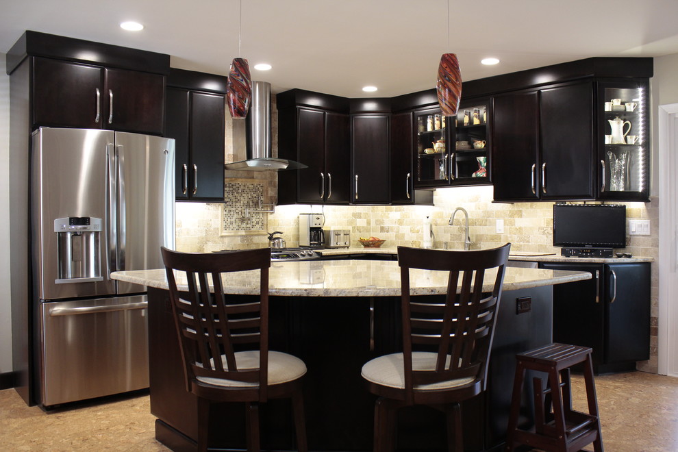 This is an example of a transitional l-shaped kitchen in Philadelphia with raised-panel cabinets, dark wood cabinets, beige splashback, mosaic tile splashback and stainless steel appliances.