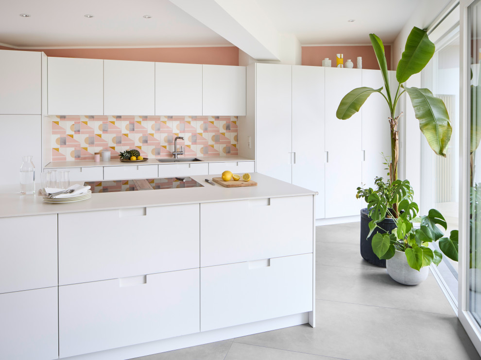 Zweizeilige Mid-Century Küche mit Unterbauwaschbecken, flächenbündigen Schrankfronten, weißen Schränken, bunter Rückwand, Kücheninsel, grauem Boden und weißer Arbeitsplatte in München