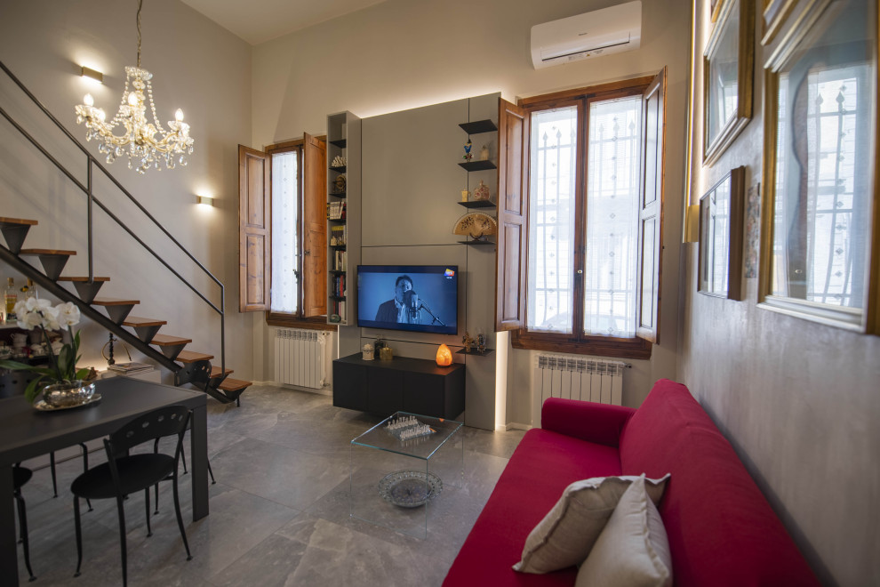 Kleines, Offenes Modernes Wohnzimmer mit grauer Wandfarbe, Porzellan-Bodenfliesen, TV-Wand, grauem Boden, eingelassener Decke und Ziegelwänden in Florenz