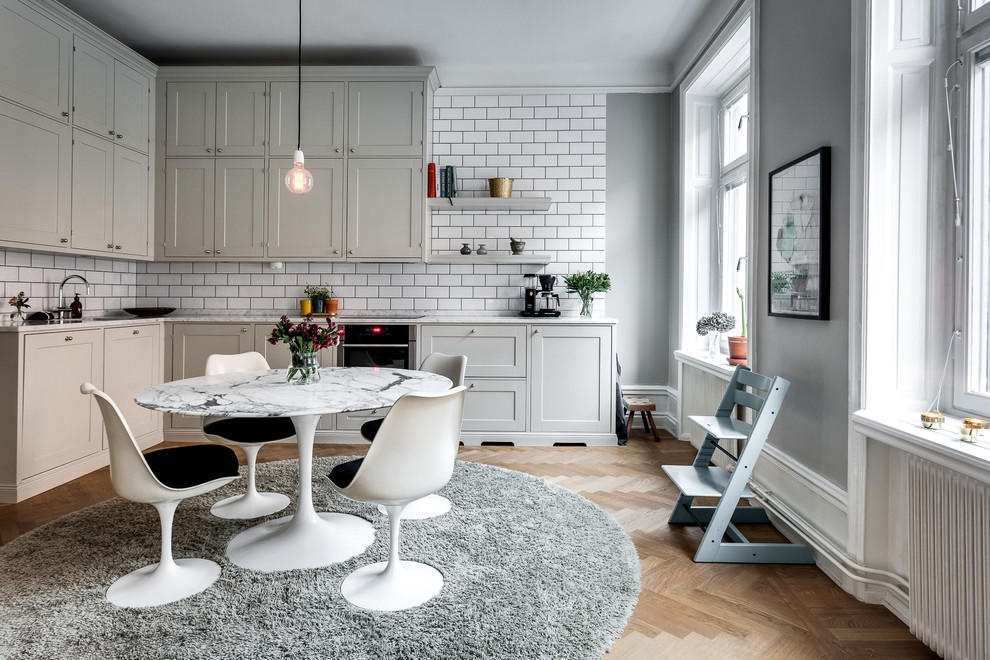 Photo of a mid-sized scandinavian kitchen/dining combo in Stockholm with grey walls and medium hardwood floors.