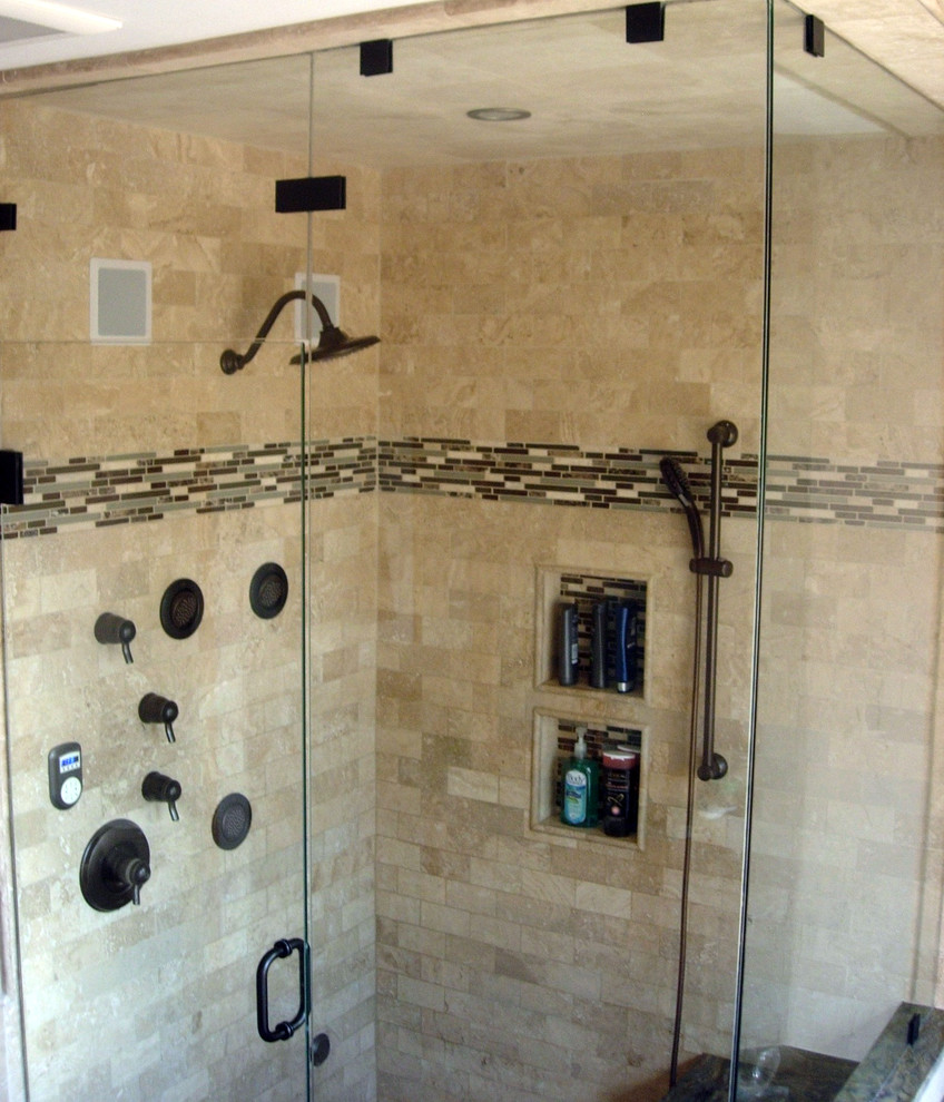 This is an example of a mid-sized transitional bathroom in Denver with raised-panel cabinets, medium wood cabinets, a drop-in tub, a two-piece toilet, beige tile, beige walls, ceramic floors, an undermount sink, granite benchtops, with a sauna, a corner shower, travertine and a hinged shower door.