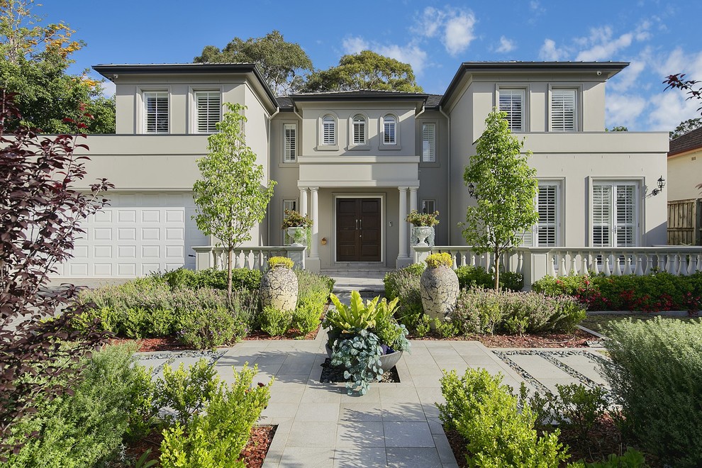 Transitional two-storey stucco grey house exterior in Sydney with a hip roof and a shingle roof.