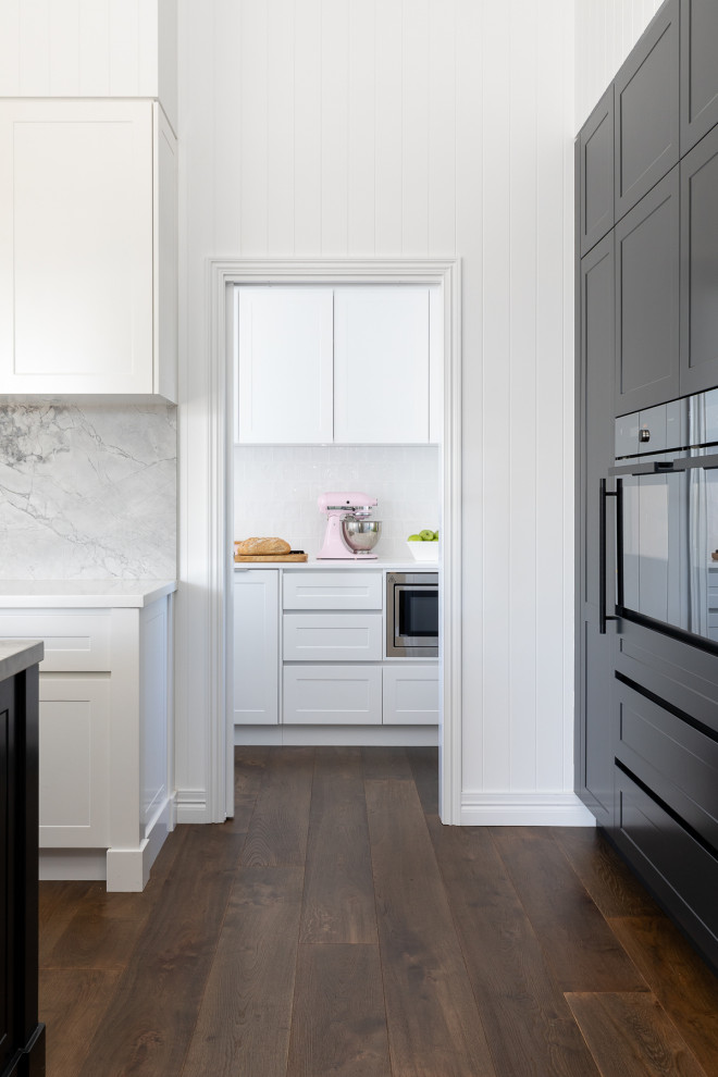 Design ideas for a large contemporary l-shaped kitchen pantry in Brisbane with an integrated sink, shaker cabinets, black cabinets, marble benchtops, grey splashback, marble splashback, black appliances, dark hardwood floors, with island, brown floor and grey benchtop.