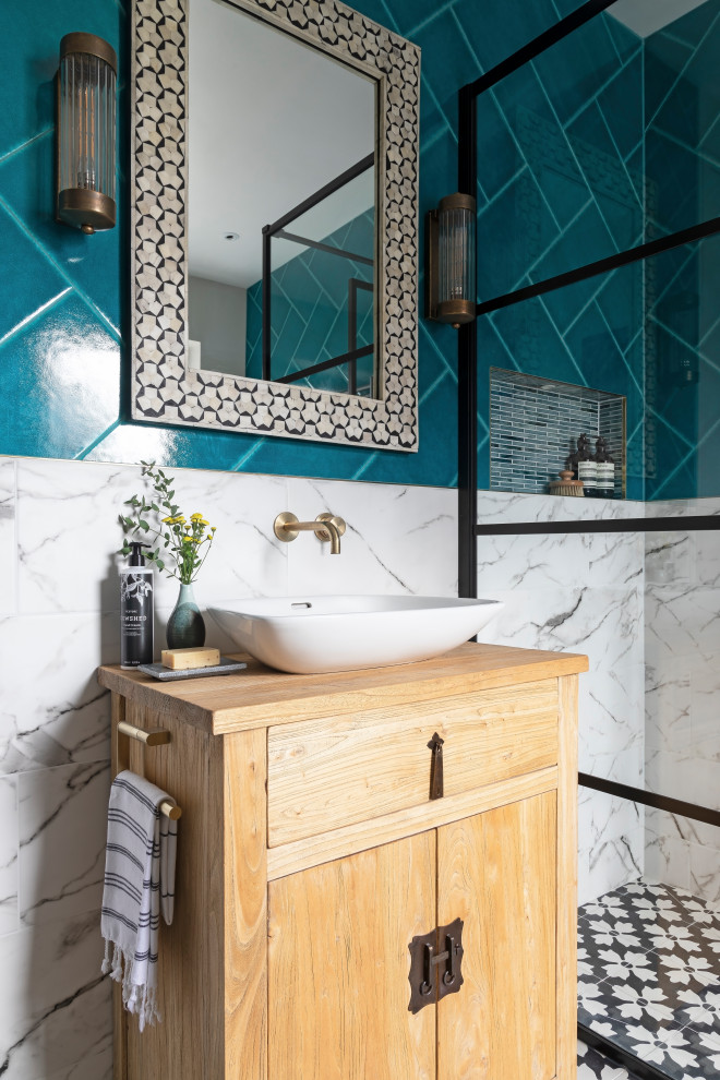 Inspiration for a mid-sized transitional kids bathroom in London with light wood cabinets, a freestanding tub, an open shower, a wall-mount toilet, multi-coloured tile, ceramic tile, multi-coloured walls, cement tiles, a vessel sink, wood benchtops, black floor, an open shower, a niche, a single vanity and a freestanding vanity.