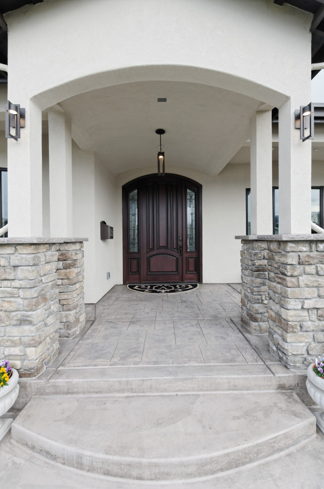 Design ideas for a contemporary front door in San Francisco with beige walls, concrete floors, a single front door, a dark wood front door, beige floor, vaulted and brick walls.