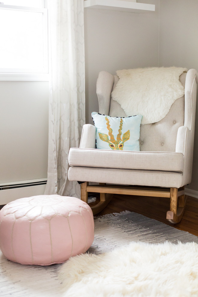 Inspiration for a mid-sized modern nursery for girls in New York with grey walls and medium hardwood floors.